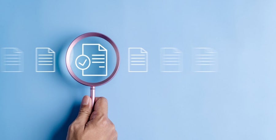 a resume icon against a blue background through a magnifying glass